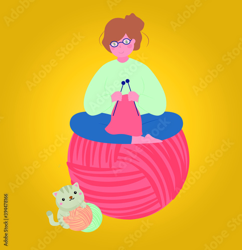 cute girl sitting on the yarn ball and knitting. the grey cat playing yarn ball. yellow background.