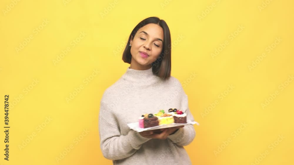 Young latin woman holding muffins dreaming of achieving goals and purposes Young latin woman holding muffins dreaming of achieving goals and purposes