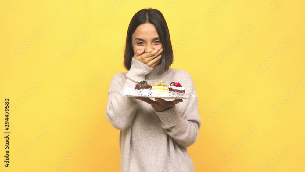 Young latin woman holding muffins receiving a pleasant surprise, excited and raising hands Young latin woman holding muffins receiving a pleasant surprise, excited and raising hands