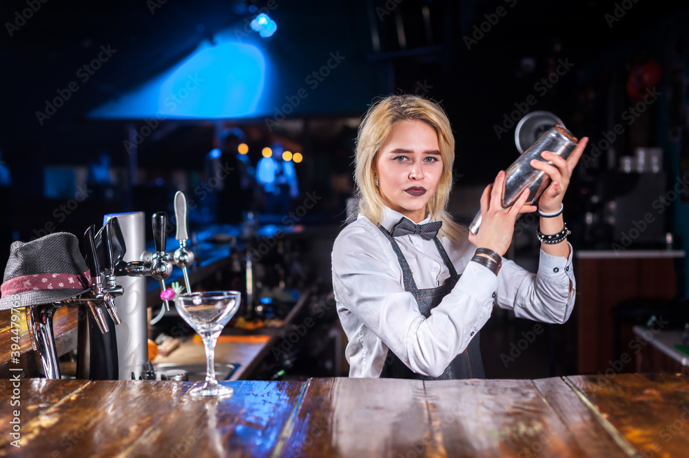 Girl bartender mixes a cocktail on the public house