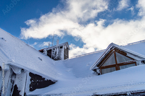 Roof covered by ice and snow on blue sky background, mountain Zakhar Berkut, Carpathian mountains, Ukraine photo