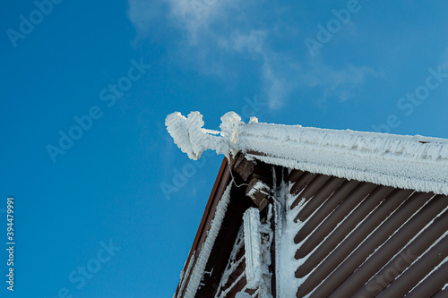 Roof covered by ice and snow on blue sky background, mountain Zakhar Berkut, Carpathian mountains, Ukraine photo