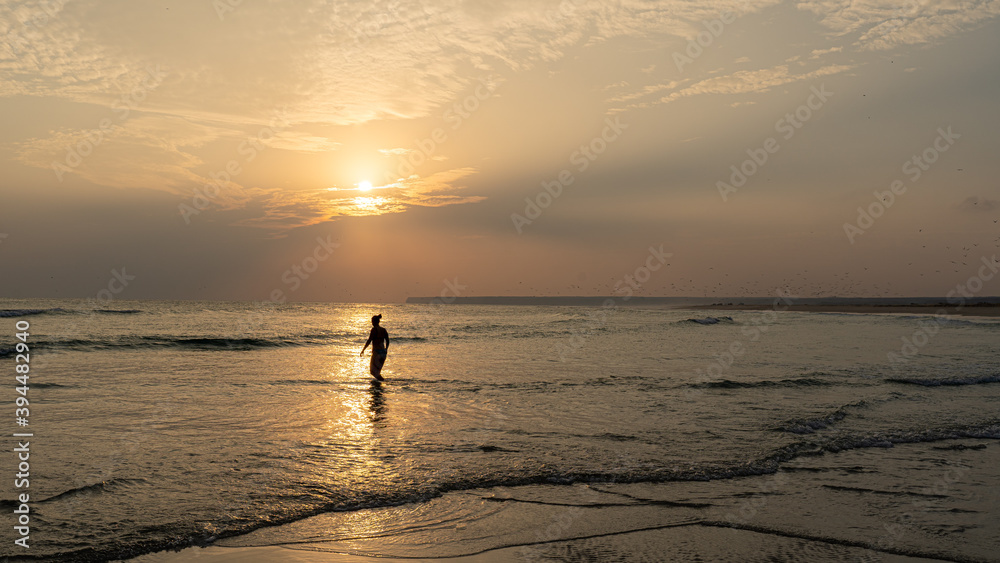 silhouette of a person on the beach during sunset silhouette of a person on the beach during sunset