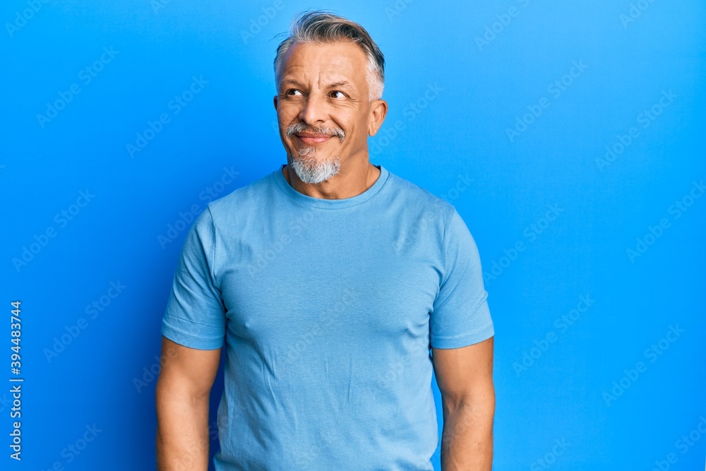 Middle age grey-haired man wearing casual clothes smiling looking to the side and staring away thinking. Middle age grey-haired man wearing casual clothes smiling looking to the side and staring away thinking.