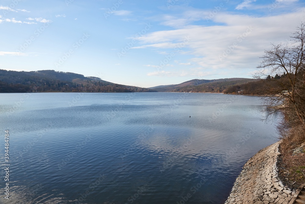 Water surface of Brno Reservoir, recreational area with hilly landscapes in the background, shot from the dam
