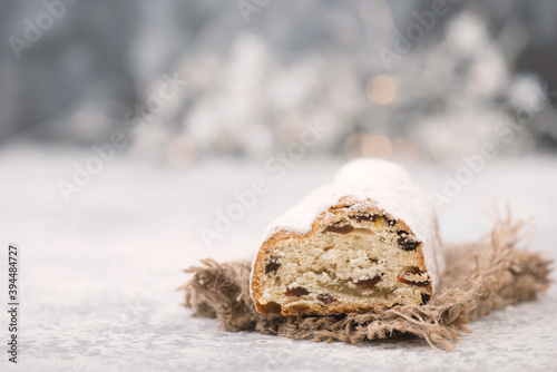 Christstollen, traditonal christmas cake with nuts, raisons, marzipan on a blue background, empty space for text