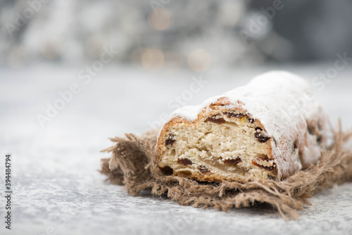 Fototapeta Naklejka Na Ścianę i Meble -  Christstollen, traditonal christmas cake with nuts, raisons, marzipan on a blue background, empty space for text