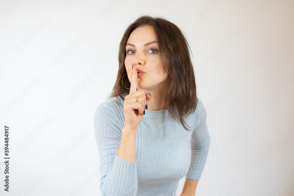 Portrait of beautiful and young woman standing over isolated white background asking to be quiet with finger on lips. Silence and secret concept. Portrait of beautiful and young woman standing over isolated white background asking to be quiet with finger on lips. Silence and secret concept.