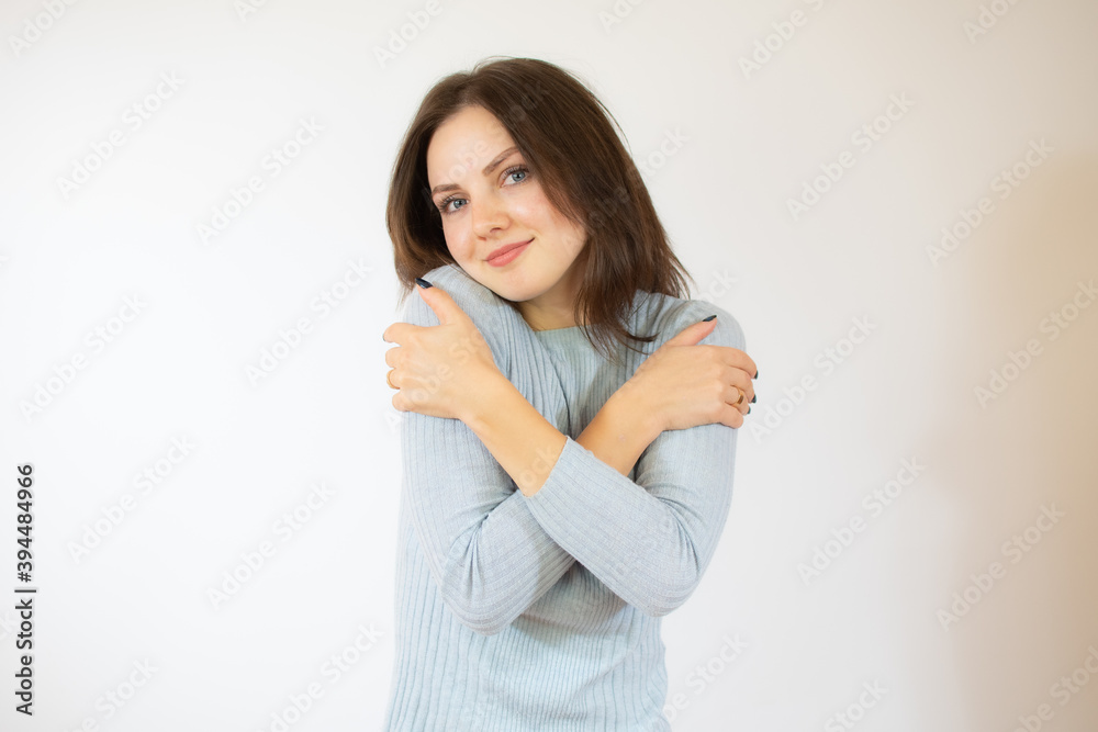 Portrait of a pretty young girl in blue sweater hugging herself. Concept of selfish emotion. Portrait of a pretty young girl in blue sweater hugging herself. Concept of selfish emotion.
