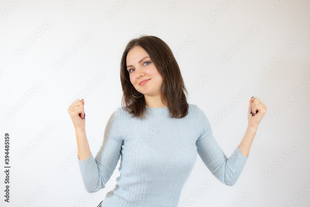 Image of excited young lady standing isolated over white background make winner gesture. Image of excited young lady standing isolated over white background make winner gesture.