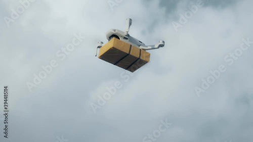 flying on a sky delivery drone with holding a .cardboard parcel photo