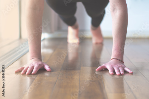 Woman doing plank exercise or push ups at home, selective focus