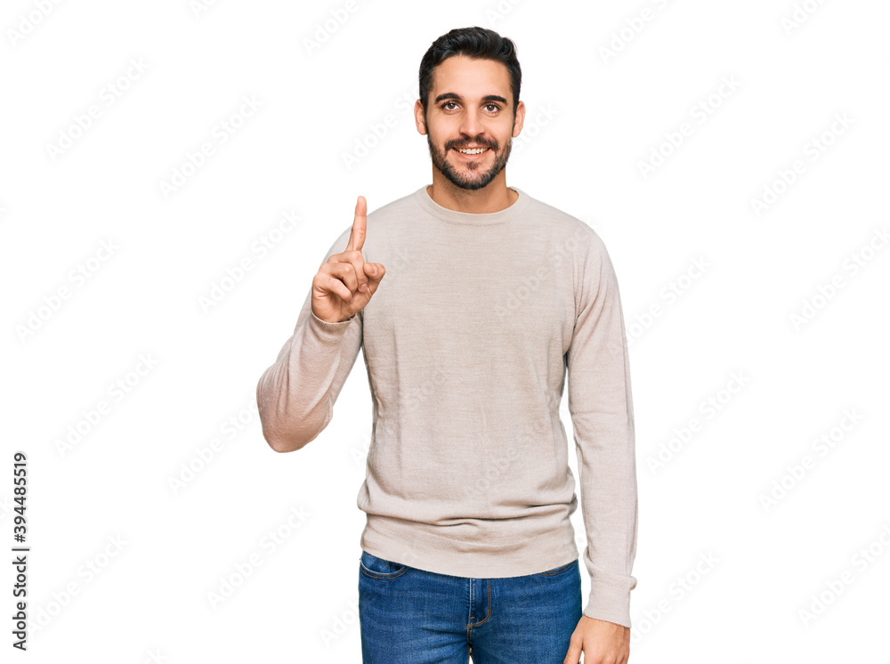 Young hispanic man wearing casual clothes showing and pointing up with finger number one while smiling confident and happy. Young hispanic man wearing casual clothes showing and pointing up with finger number one while smiling confident and happy.