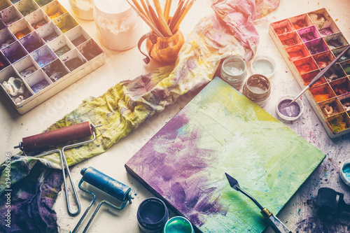 Konstfotografi Artistic equipment: canvas and palette knife, paint brushes, multicolored paints in artist studio