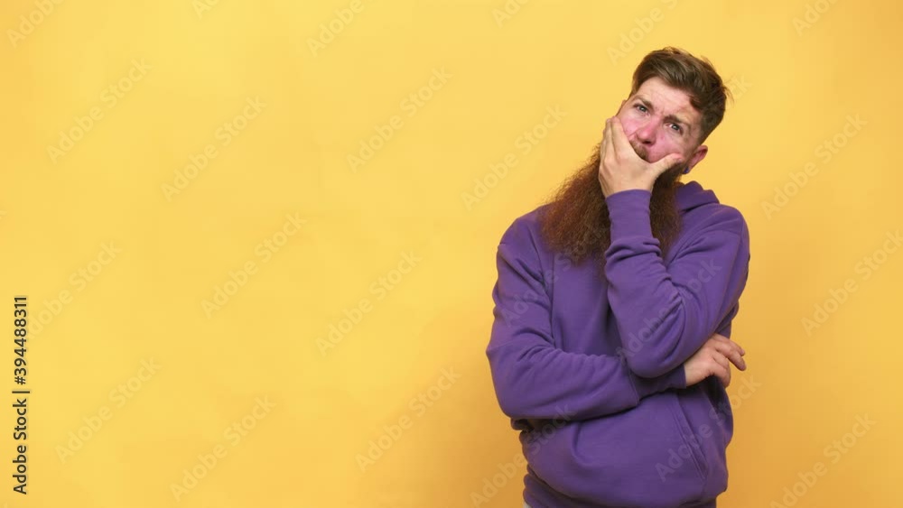 Young adult bearded caucasian man isolated thoughtful looking to a copy space covering mouth with hand Young adult bearded caucasian man isolated thoughtful looking to a copy space covering mouth with hand