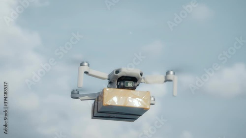 flying on a sky delivery drone with holding a .cardboard parcel photo