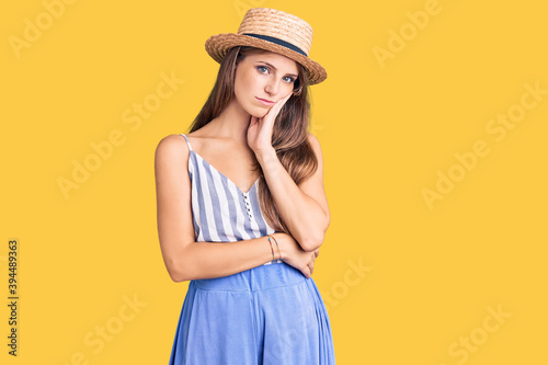 Young beautiful blonde woman wearing summer hat thinking looking tired and bored with depression problems with crossed arms.
