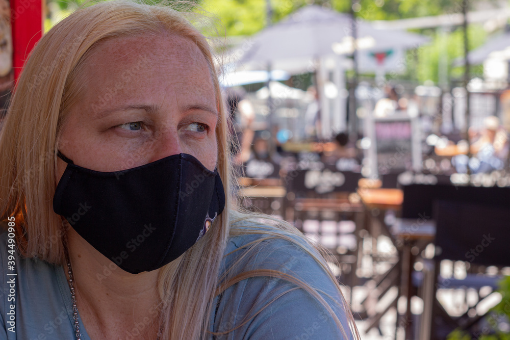 Woman with face mask sitting in a bar. Woman with face mask sitting in a bar.