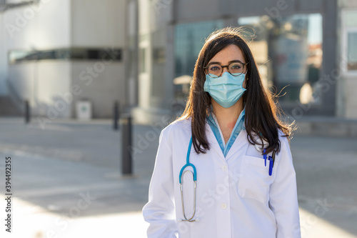 Female doctor at the emergency door of the hospital, against COVID19