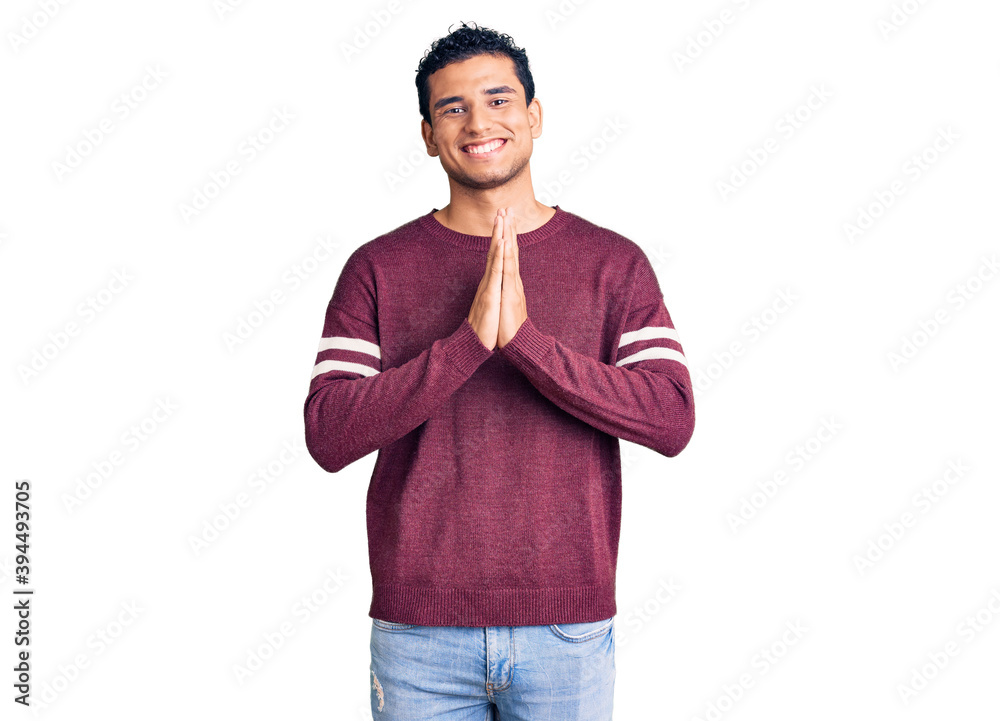 Hispanic handsome young man wearing casual clothes praying with hands together asking for forgiveness smiling confident. Hispanic handsome young man wearing casual clothes praying with hands together asking for forgiveness smiling confident.