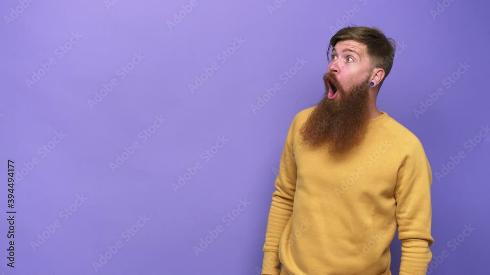Young adult bearded caucasian man isolated being shocked because of something she has seen Young adult bearded caucasian man isolated being shocked because of something she has seen