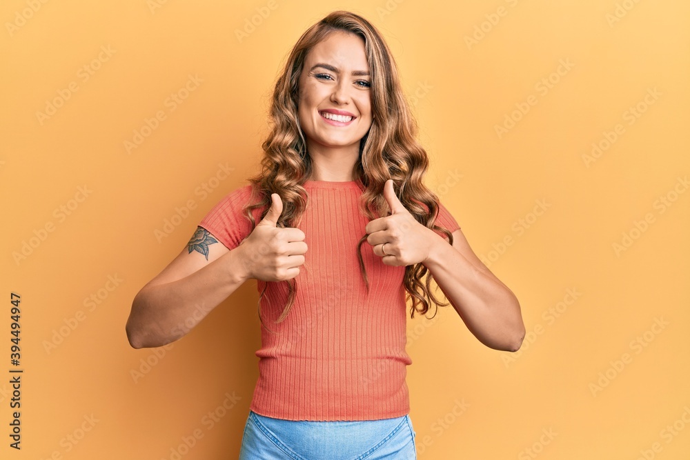 Young blonde girl wearing casual clothes success sign doing positive gesture with hand, thumbs up smiling and happy. cheerful expression and winner gesture. Young blonde girl wearing casual clothes success sign doing positive gesture with hand, thumbs up smiling and happy. cheerful expression and winner gesture.