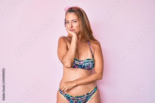 Middle age hispanic woman wearing bikini thinking looking tired and bored with depression problems with crossed arms.