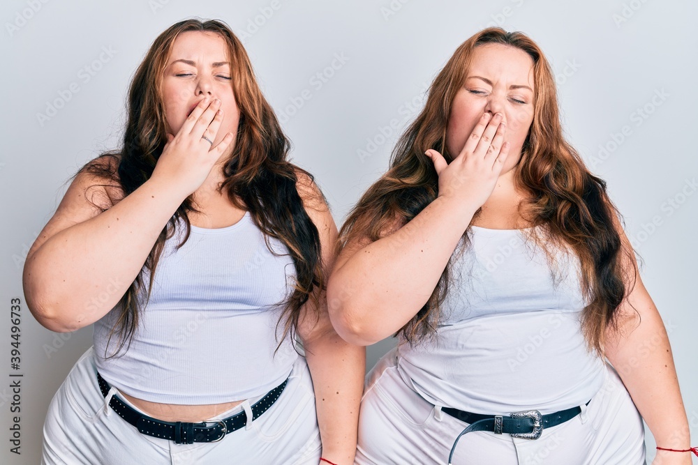 Plus size caucasian sisters woman wearing casual white clothes bored yawning tired covering mouth with hand. restless and sleepiness. Plus size caucasian sisters woman wearing casual white clothes bored yawning tired covering mouth with hand. restless and sleepiness.