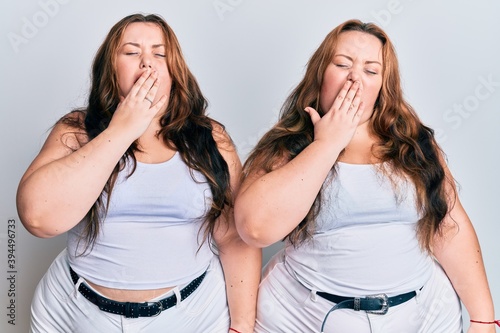 Plus size caucasian sisters woman wearing casual white clothes bored yawning tired covering mouth with hand. restless and sleepiness.