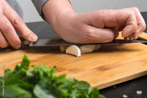 cook crushes the garlic with a knife