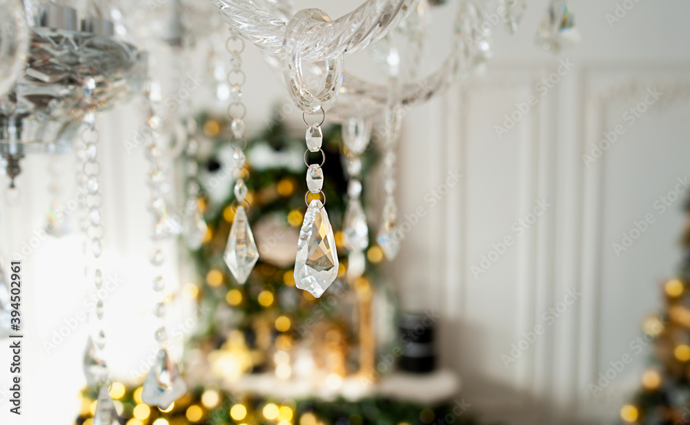 crystal stylish vintage pendant chandelier with crystals and beads close-up in festive interior and Golden lights and bokeh, selective focus