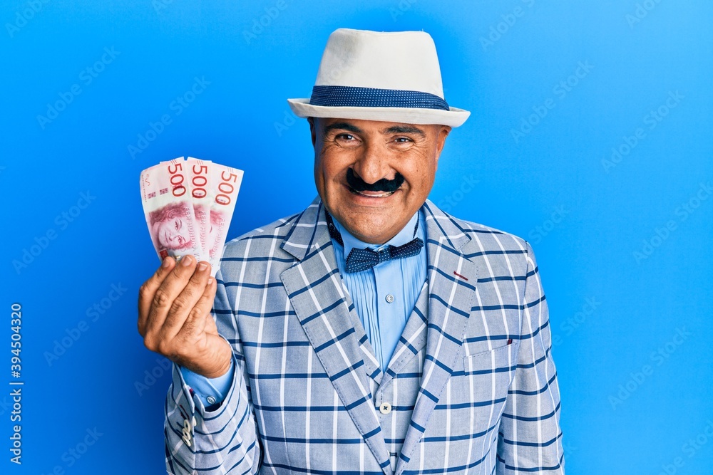 Mature middle east man with mustache wearing elegant vintage style looking positive and happy standing and smiling with a confident smile showing teeth Mature middle east man with mustache wearing elegant vintage style looking positive and happy standing and smiling with a confident smile showing teeth