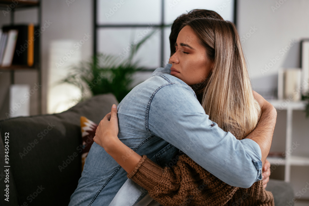 Fototapeta premium Young man having a problem. Girlfriend comforting her sad boyfriend.