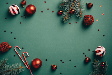 Vintage Christmas background with red and white balls decoration, fir tree branches, candy canes, confetti. Retro Christmas card template.