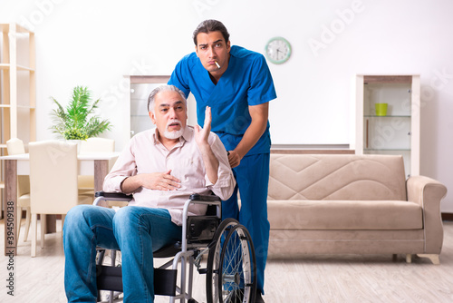 Old man in wheel-chair and young bad caregiver indoors