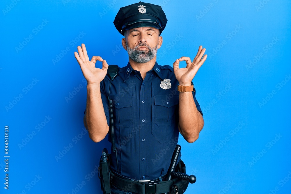 Middle age handsome man wearing police uniform relaxed and smiling with eyes closed doing meditation gesture with fingers. yoga concept. Middle age handsome man wearing police uniform relaxed and smiling with eyes closed doing meditation gesture with fingers. yoga concept.