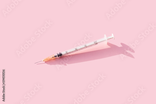 Syringe of pink background. Colorful concept of New Corona virus 2019-nCoV or COVID-19 vaccine. Creative minimal medicinal background.