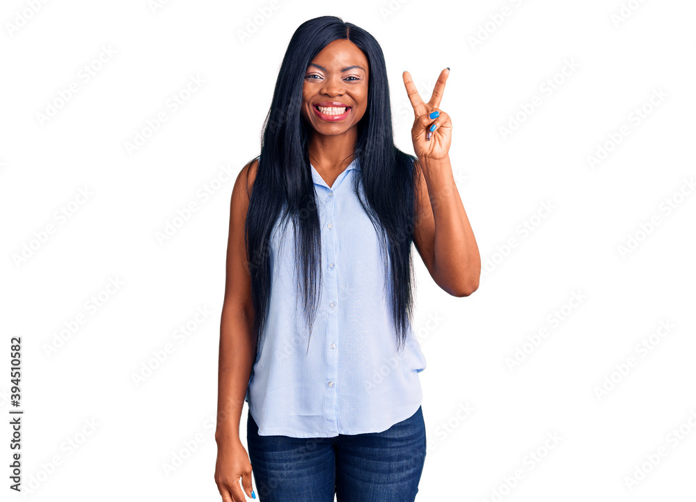 Young african american woman wearing casual clothes showing and pointing up with fingers number two while smiling confident and happy. Young african american woman wearing casual clothes showing and pointing up with fingers number two while smiling confident and happy.