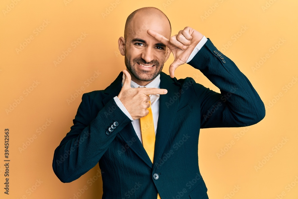 Hispanic bald man wearing business suit and tie smiling friendly offering handshake as greeting and welcoming. successful business. Hispanic bald man wearing business suit and tie smiling friendly offering handshake as greeting and welcoming. successful business.