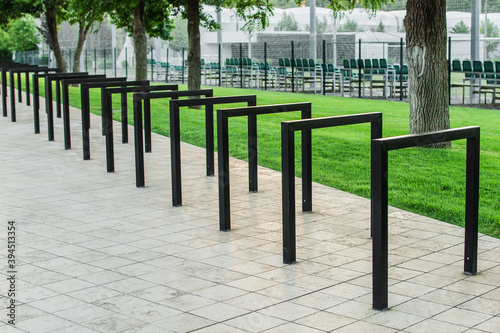 Empty bicycle parking racks in park. Metal construction for Parking of bicycles, scooters, environmental transport in the city. Eco-friendly and sports transport in the city.