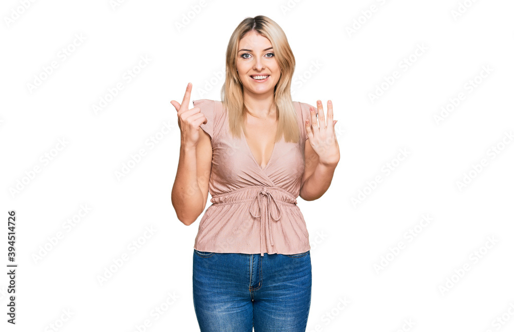Young caucasian woman wearing casual clothes showing and pointing up with fingers number seven while smiling confident and happy. Young caucasian woman wearing casual clothes showing and pointing up with fingers number seven while smiling confident and happy.