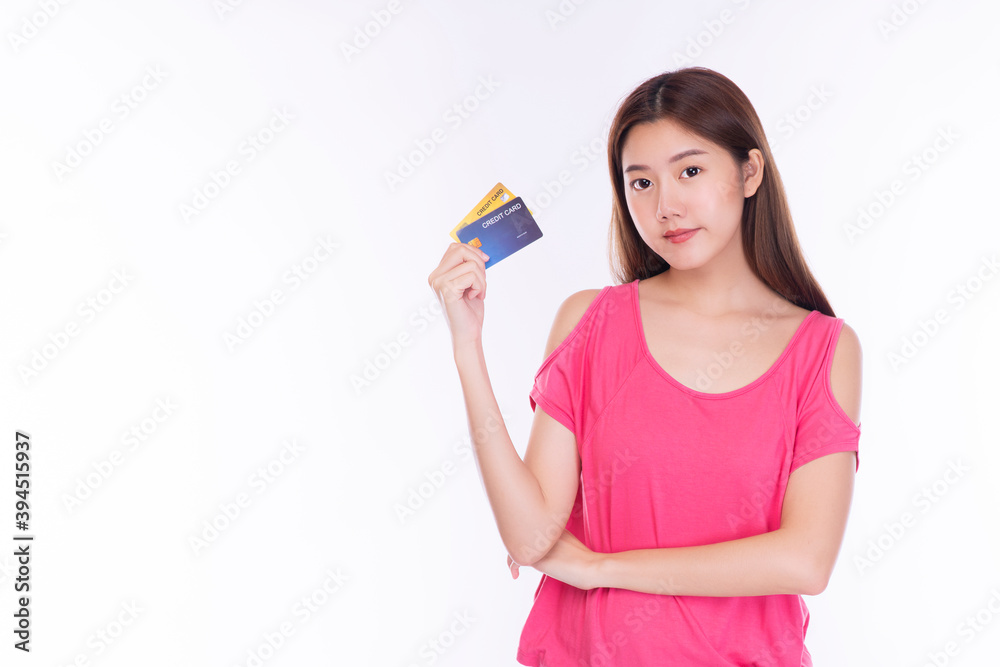 Payment purchase and financial concept. Friendly young woman wearing casual clothes while holding credit card mockup in her hand and looking at camera over isolated white background. Payment purchase and financial concept. Friendly young woman wearing casual clothes while holding credit card mockup in her hand and looking at camera over isolated white background.