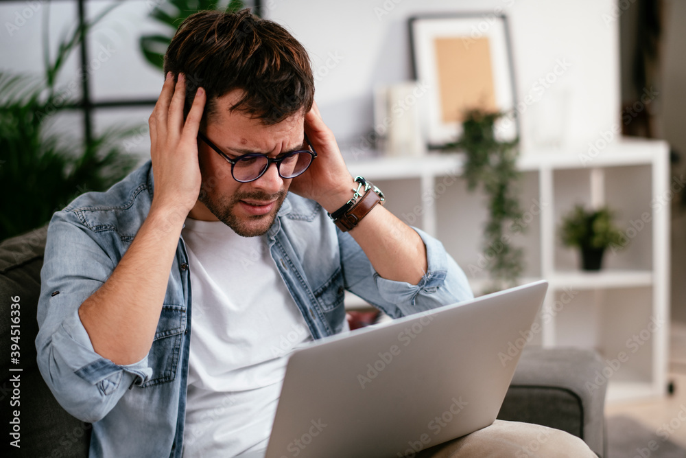Young man having video call. Man sitting in the living room and using the laptop. Young man having video call. Man sitting in the living room and using the laptop.