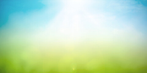Blurred nature background with green meadow and blue sky under bright sunlight