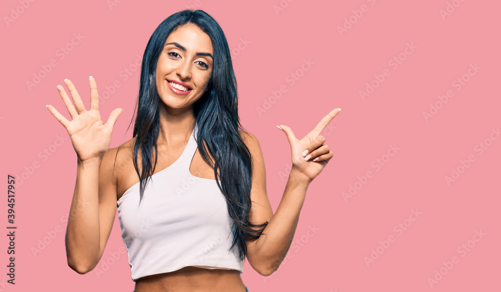 Beautiful hispanic woman wearing casual clothes showing and pointing up with fingers number seven while smiling confident and happy. Beautiful hispanic woman wearing casual clothes showing and pointing up with fingers number seven while smiling confident and happy.