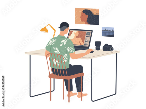 Photographer works at computer and edits photos