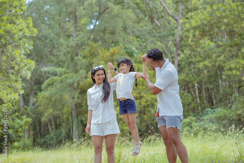 Happy asian family with daughter playing and travel in forest on weekend
