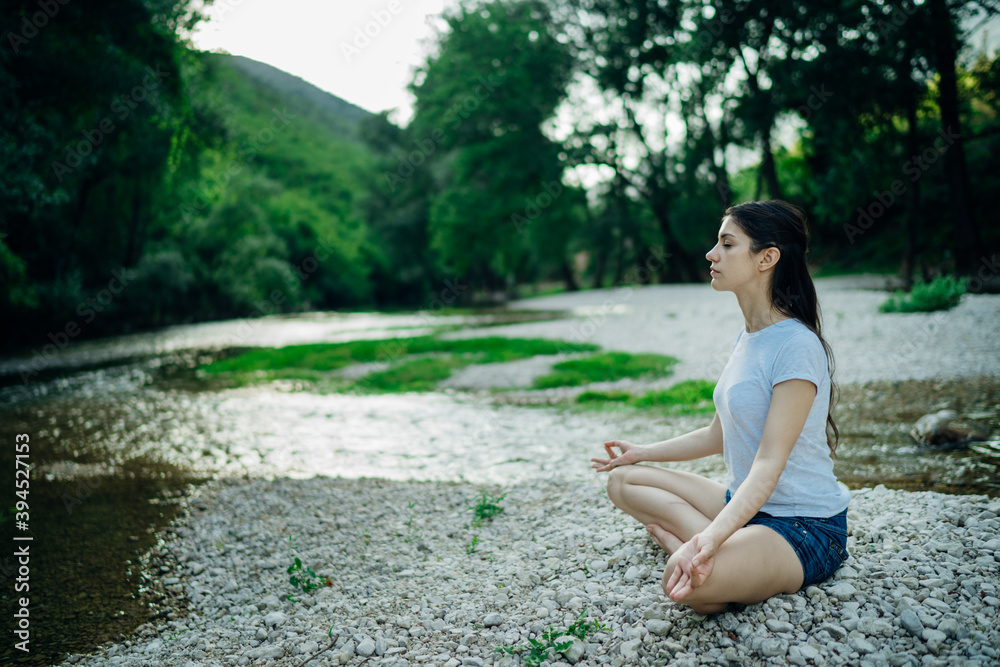 Meditation yoga woman siting at Lotus position on the shore of river.Serenity and yoga practice.Healthy lifestyle.Self isolation in nature.Lockdown beach trip.Mindfulness.Breathing exercise Meditation yoga woman siting at Lotus position on the shore of river.Serenity and yoga practice.Healthy lifestyle.Self isolation in nature.Lockdown beach trip.Mindfulness.Breathing exercise
