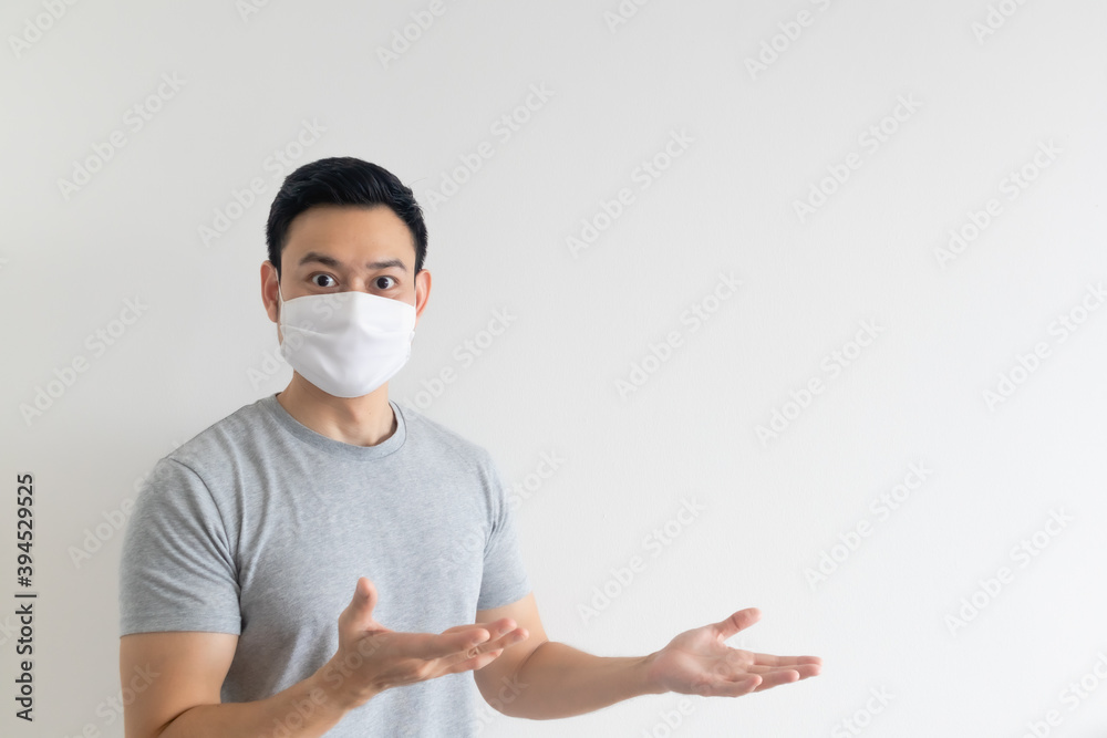 Asian man in white mask presenting the empty copy space on isolated background. Asian man in white mask presenting the empty copy space on isolated background.