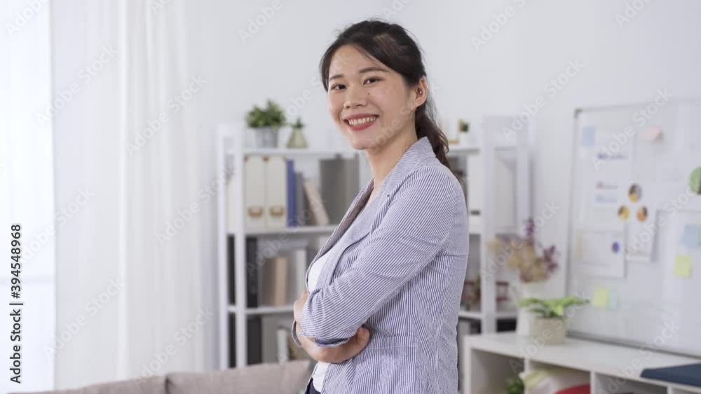 confident and professional asian female manager in blazer facing camera is standing with arms crossed and smiling. confident and professional asian female manager in blazer facing camera is standing with arms crossed and smiling.